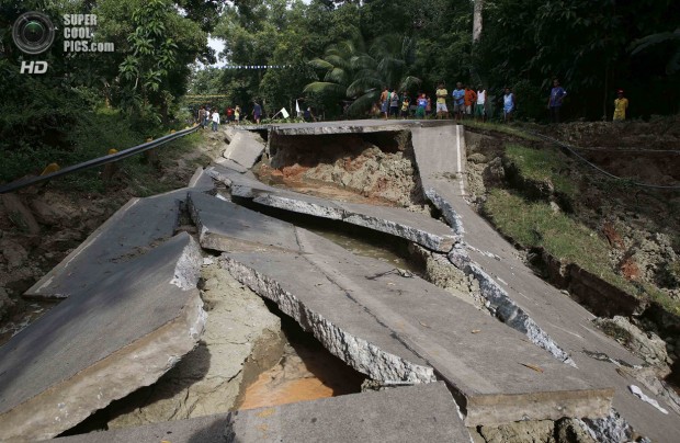 Villagers stand near portion of a damaged highway in Getafe