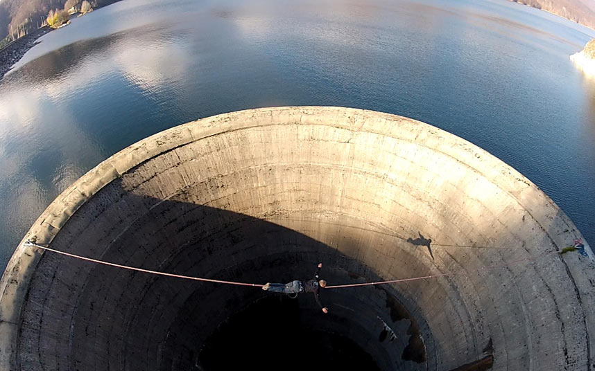 Смельчак слэклайнер пересекает 61-метровый слив водохранилища