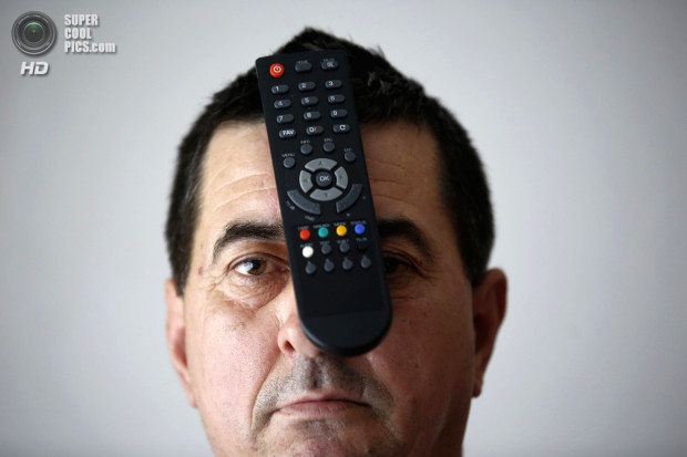 Buljubasic, 56, poses with a TV remote on his head in Srebrenik