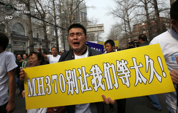 A family member of a passenger aboard Malaysia Airlines MH370 cries during a protest in Beijing