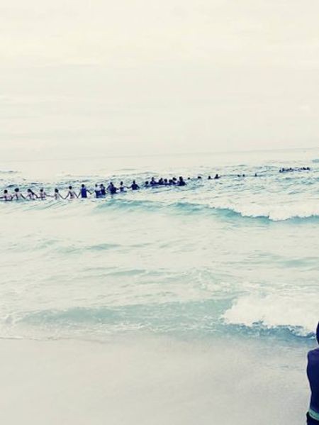 Отдыхающие на пляже выстроились в живую цепь, чтобы спасти утопающих (2 фото)