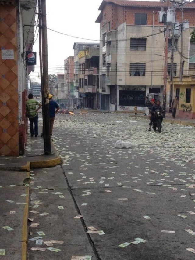 Жители Венесуэлы выбрасывают на улицу обесцененную валюту (4 фото)