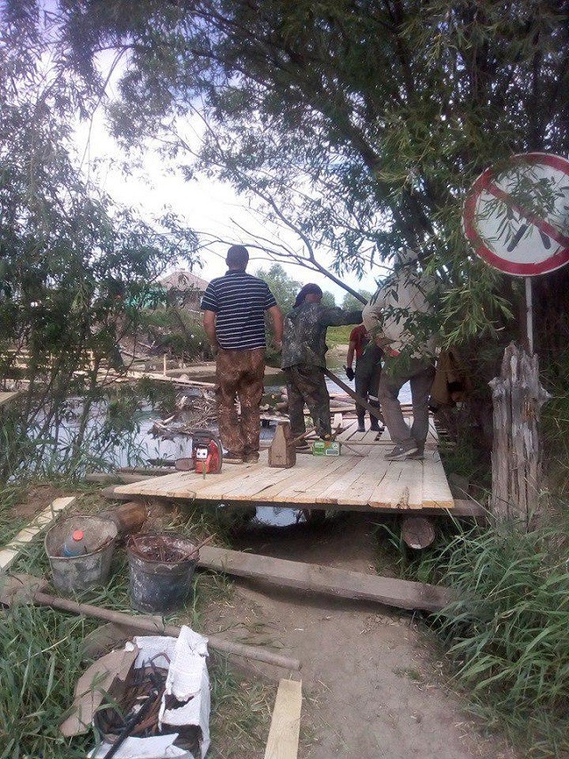 Местные жители своими силами строят мост через реку (6 фото)