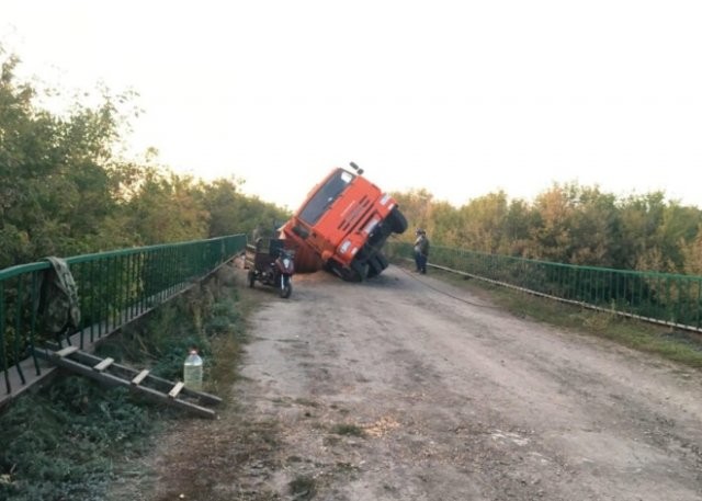 «Немного» перегруженный «КАМАЗ» проломил мост (5 фото)