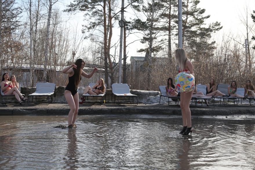 В Новосибирске девушки в купальниках загорали на берегу большой лужи (8 фото)