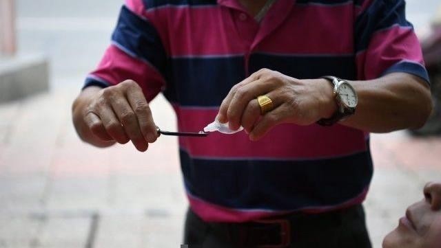 Престарелый китаец чистит глаза всем желающим опасной бритвой (5 фото)
