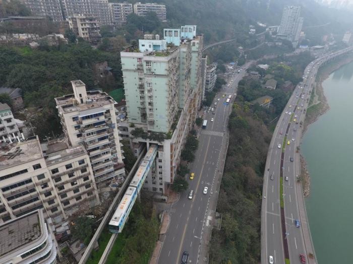 Поезд проходит через центр 19-этажного жилого дома в Китае (9 фото)