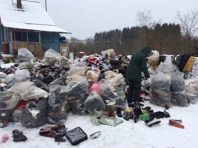 В Ленинградской области у одного из домов высыпали гору одежды (3 фото)
